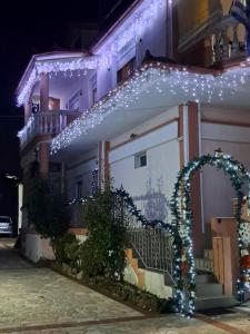 a house with christmas lights on the side of it at Erodios Guesthouse in Kato Loutraki