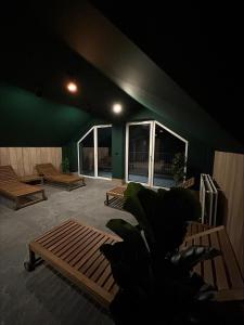 a room with benches and a green wall with windows at Ostoja_Szklarska_Poręba in Szklarska Poręba