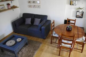 a living room with a blue couch and a table at Cosy ferme de village en baie du Mont Saint Michel in Vains