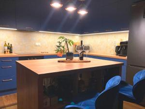 a kitchen with a table with a wine glass and a plant at Gold Apart - podziemny garaż Blisko stadionu i lotniska - Wygoda, styl i komfort in Poznań