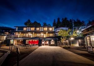 un gran edificio por la noche con luces encendidas en Ryokan Sakaya, en Nozawa Onsen