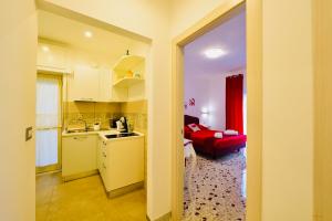 a kitchen and a living room with a red couch at Floral Holiday in Minori