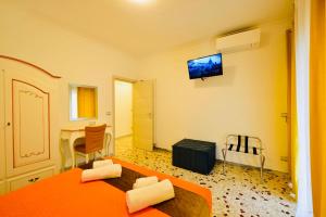 a room with a bed and a table and a television at Floral Holiday in Minori