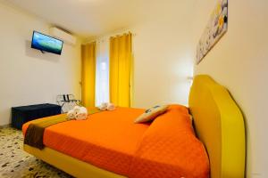 a bedroom with an orange bed with two stuffed animals on it at Floral Holiday in Minori