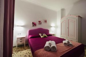ein Schlafzimmer mit einem lila Bett mit Schuhen drauf in der Unterkunft Floral Holiday in Minori