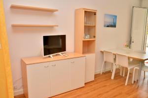 a living room with a desk with a tv and a table at Comfortable villa for 6 guests - Beahost Rentals in Bibione