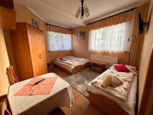 a bedroom with two beds and a table in it at Pokoje Gościnne U Babci in Zakopane