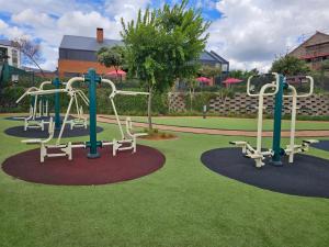 a playground in a park with two slides and benches at @The Genesis near OR Tambo Airport in Boksburg