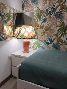 a bedroom with a bed with a vase on a night stand at Apartamento Soleado in Los Abrigos