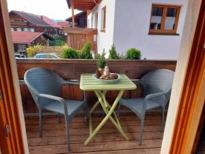 a small table on a balcony with two chairs at Ferienwohnungen Beargzit in Bad Hindelang