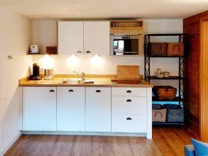 a kitchen with white cabinets and a sink at Ferienwohnungen Beargzit in Bad Hindelang
