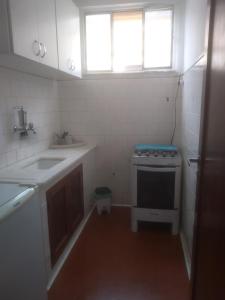 a small kitchen with a sink and a stove at Apartamento Jardim Cascata in Teresópolis