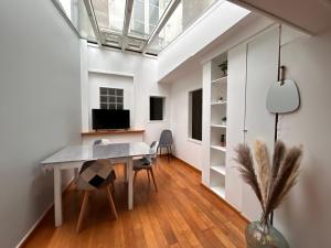 een eetkamer met een tafel en een tv bij Home Preize in Troyes