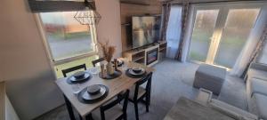 a dining table and chairs in a living room at Lynton lodges ATLAS in Evanton