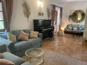 sala de estar con sofá y piano en Terra di Mezzo en Volterra