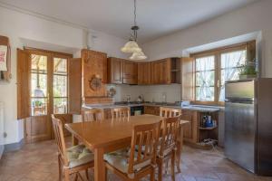a kitchen with a table and chairs and a refrigerator at Terra di Mezzo in Volterra