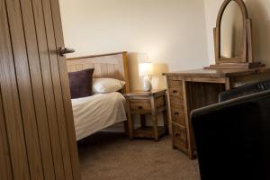 a bedroom with a bed and a dresser at Riverside Apartments in Wick
