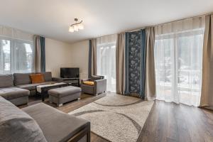 sala de estar con sofá y TV en Apartamenty Tyrol en Szczawnica