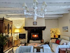 un soggiorno con divano e camino di Breizh home A la Boissière a Merléac