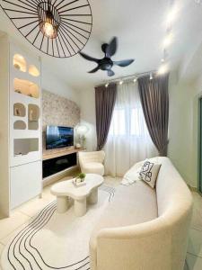 een woonkamer met een bank en een plafondventilator bij The Clouds by eladeko in Sepang