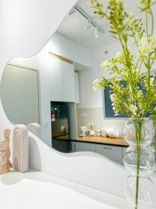 een witte keuken met een vaas met bloemen erin bij The Clouds by eladeko in Sepang