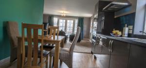 a kitchen with a table and a dining room at Riverside Apartments in Wick