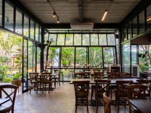 a restaurant with tables and chairs and windows at Crystal Resort Korat in Nakhon Ratchasima