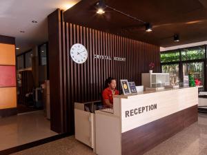 a woman sitting at a reception desk in an office at Crystal Resort Korat in Nakhon Ratchasima