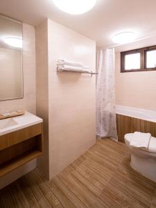 y baño con aseo, lavabo y ducha. en Crystal Resort Korat en Nakhon Ratchasima