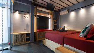 a bedroom with a red bed and a large window at Rockinnest Hotel El Nido in El Nido