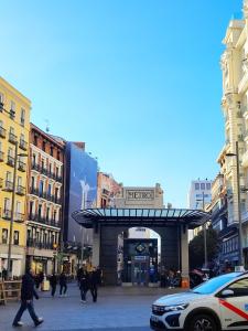 a group of people crossing a street in a city at Madrid Centro Rooms in Madrid