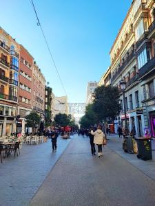 a group of people walking down a city street at Madrid Centro Rooms in Madrid