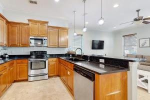 a kitchen with wooden cabinets and stainless steel appliances at Villages of Crystal Beach Family Tides in Destin