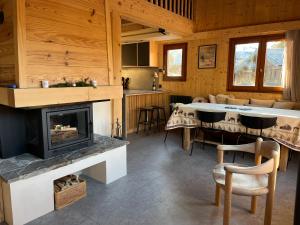 cocina y sala de estar con chimenea y mesa en Chalet L'AS DE CARROZ, en Arâches-la-Frasse