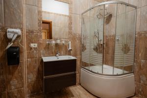 uma casa de banho com um chuveiro e um lavatório. em Hotel Royal em Râmnicu Vâlcea