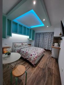 een slaapkamer met een bed en een tafel en een blauw plafond bij IL CUORE DEL CONERO - CASALE CON PISCINA, Natura e Relax in Camerano