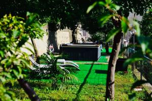 un parc avec un banc dans l'herbe planté d'arbres dans l'établissement Eden Holiday, à Minori