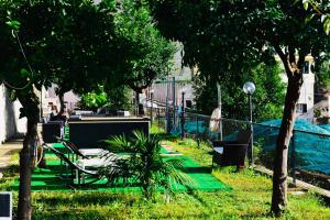 un parque con un grupo de mesas y árboles en Eden Holiday en Minori