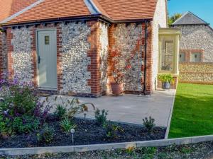 a brick house with a door and a yard at Blundens Holiday Lets - Dawmill in Chichester