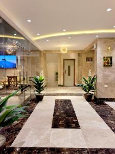 a lobby with two plants in a building at Jasmine Inn Deluxe in Badr