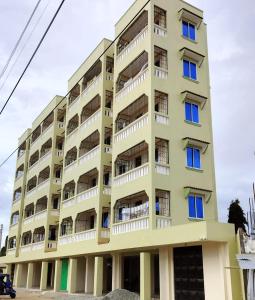 un edificio de apartamentos con balcones blancos y ventanas azules en Hide Out Homes, en Mombasa
