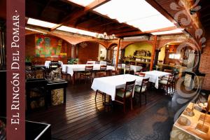 Del Pomar Hotel Boutique في ريزيستينسيا: مطعم بطاولات بيضاء وكراسي في الغرفة