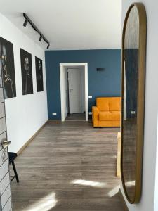 a hallway with an orange couch and a mirror at ApartLupeni in Lupeni