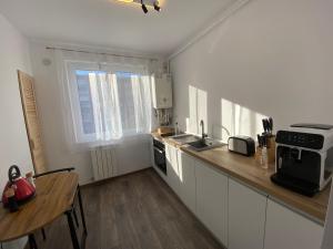a kitchen with white cabinets and a wooden counter top at ApartLupeni in Lupeni
