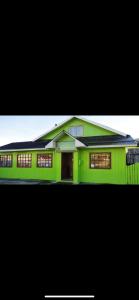 una casa verde con ventanas en la parte superior en Hostal Beagle en Puerto Williams
