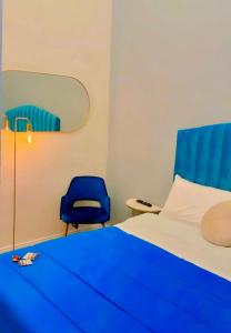 - une chambre avec un lit bleu et une chaise bleue dans l'établissement Home Piccini, à Naples