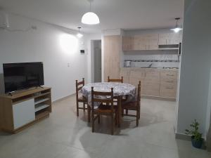 een keuken en eetkamer met een tafel en een televisie bij LA CUECA in La Cieneguita +3 foto's