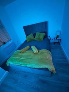 a bed in a room with a blue light at Apartment Near Leeds City Centre Sleeps 4 in Beeston Hill