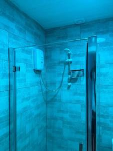baño con ducha con luz azul en Apartment Near Leeds City Centre Sleeps 4 en Beeston Hill