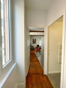 a hallway leading into a living room with a window at Charming appartement with a view of the Saone in Mâcon